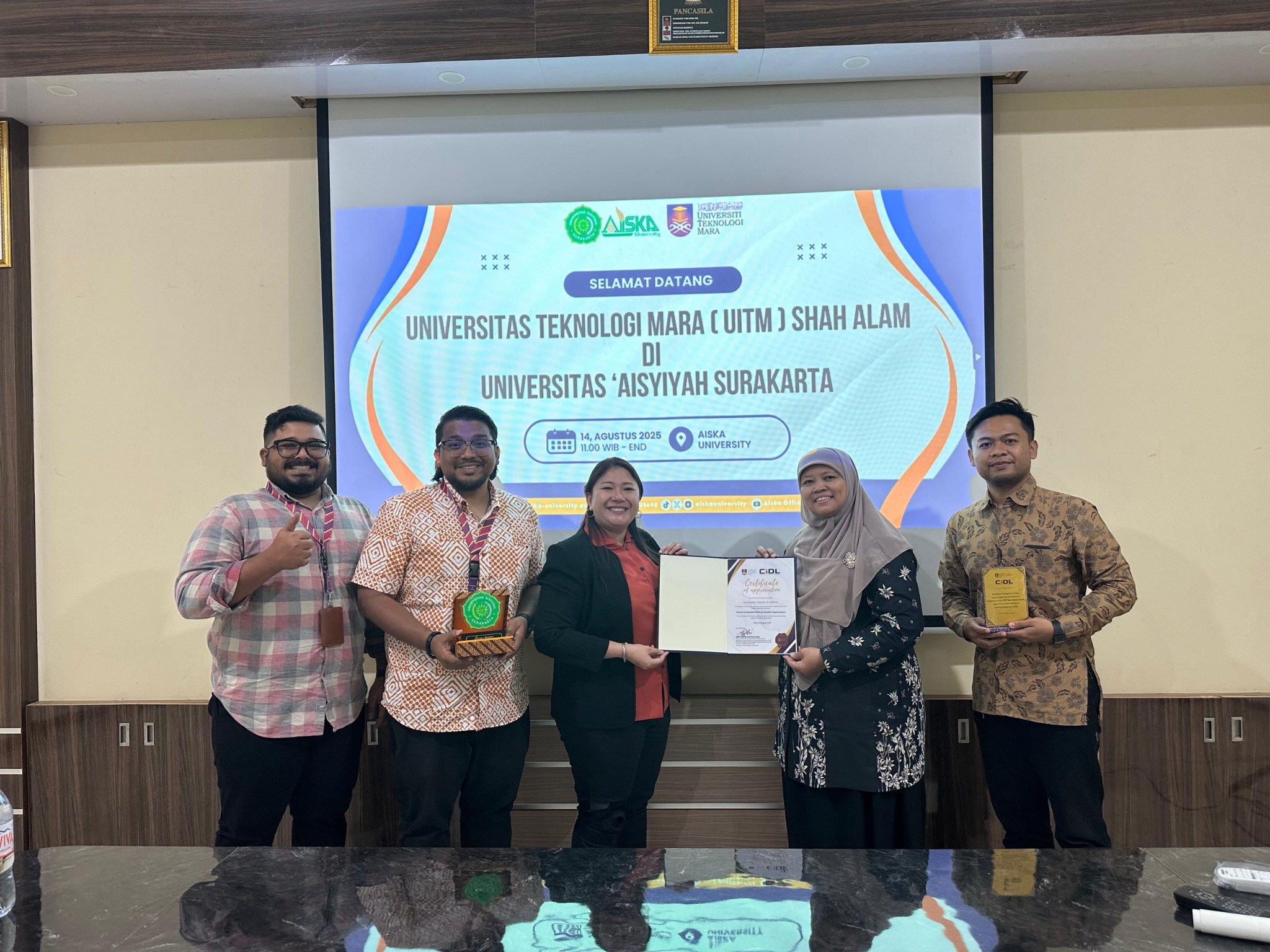 Fitri and colleagues at Universitas ’Aisyiyah Surakarta holding certificates and plaques